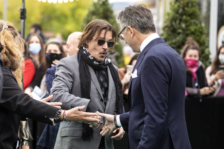 epa08715824 US actor Johnny Depp (L) and Artistic Director Zurich Film Festival Christian Jungen (R) arrive at the 16th Zurich Film Festival (ZFF) in Zurich, Switzerland, 02 October 2020. The festival ...