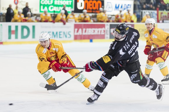 Le defenseur de Langnau Miro Zryd, gauche, lutte pour le puck avec l&#039;attaquant fribourgeois Mattias Ritola, droite, lors du match du championnat suisse de hockey sur glace de National League A en ...