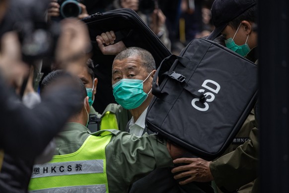 epa09623471 Media mogul Jimmy Lai (C) is escorted out of a Correctional Services Department vehicle and into the Court of Final Appeal in Hong Kong, China, 09 February 2021. Lai returned to court and  ...