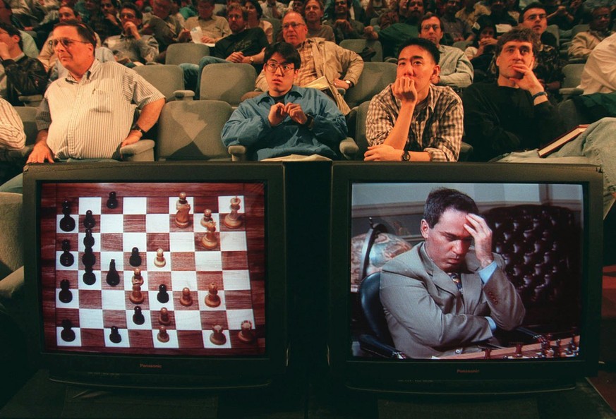 An audience watches as Garry Kasparov is shown on a television screen contemplating his next move against Deep Blue, IBM&#039;s chess playing computer, during the second game of their six game rematch ...