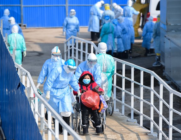 epa08191654 Medical staff transfer patients to the newly completed Huoshenshan temporary field Hospital in Wuhan, Hubei Province, China 04 February 2020. The global coronavirus death toll had rose to  ...