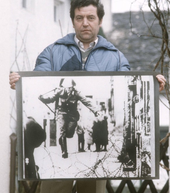 Conrad Schumann (Ex-DDR-Volkspolizist) 03/86 ru Ex-DDR-Volkspolizist Conrad Schumann im März 1986 mit dem Foto seiner Flucht vom 15. August 1961, fotografiert von Peter Leibing