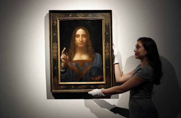 FILE - In this Oct. 24, 2017 file photo, an employee poses with Leonardo da Vinci&#039;s &quot;Salvator Mundi&quot; on display at Christie&#039;s auction rooms in London. Poland’s culture minister has ...