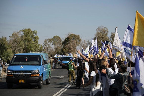 People react as a convoy carrying the hostages released from the Gaza Strip arrives at a military base near Reim, southern Israel, on Monday, Oct. 13, 2025. (AP Photo/Leo Correa)
Israel Palestinians G ...