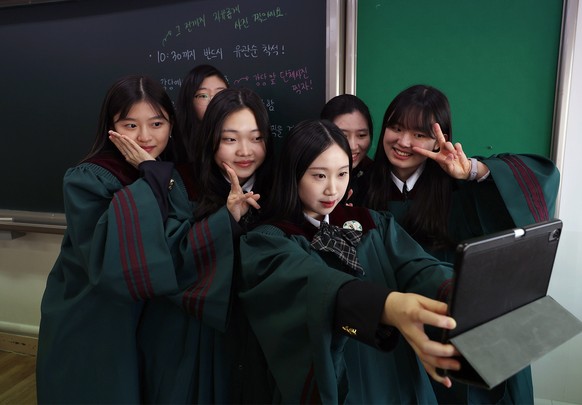 epa10453914 A group of senior students takes a selfie after attending a graduation ceremony at Ewha Girls&#039; High School in Seoul, South Korea 08 February 2023. EPA/YONHAP SOUTH KOREA OUT