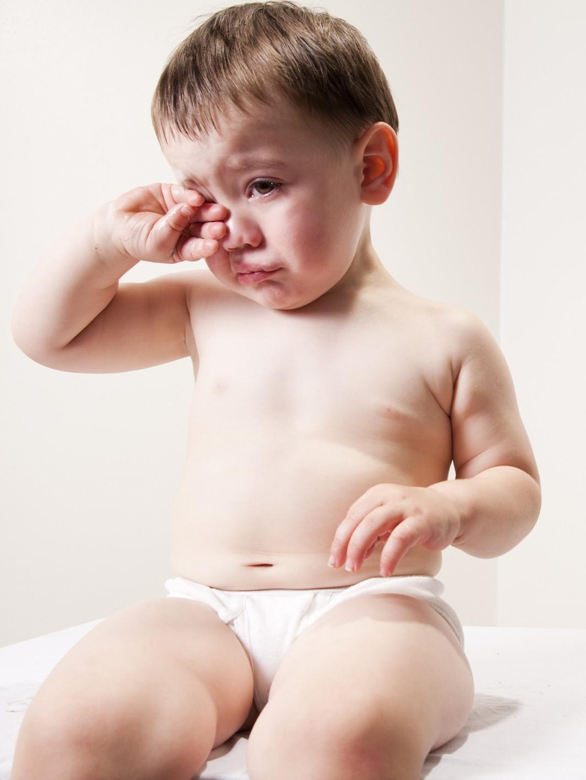 Weinen Baby - Stock-Fotografie
A baby wiping his eyes from crying. There is a three layered chocolate cake next to him with a fork.