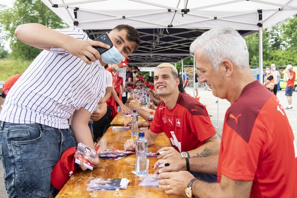 Vladimir Petkovic, Trainer der Schweizer Nationalmannschaft und Granit Xhaka geben nach ihrem Ausscheiden im Viertelfinal der Fussball Europameisterschaft 2020 am Flughafen in Zuerich Autogramme, aufg ...