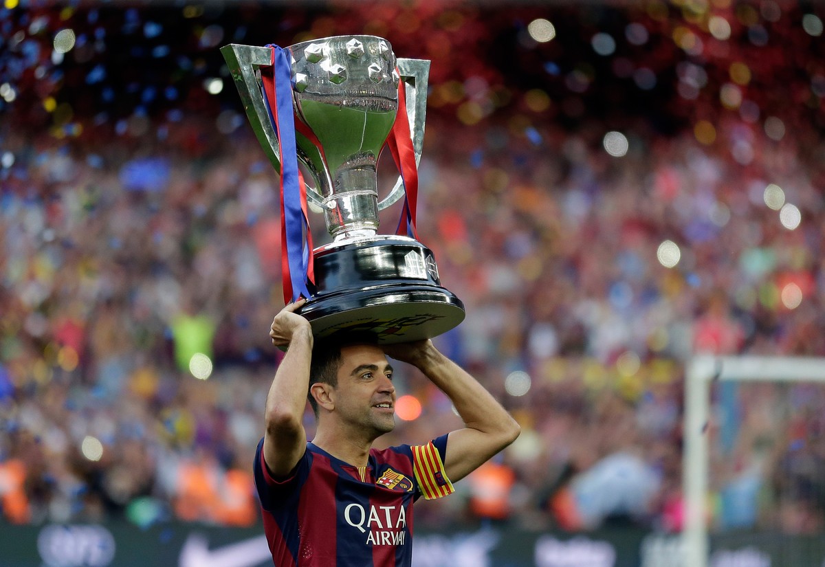 FC Barcelona's Xavi Hernandez holds up the trophy after winning the Spanish League title, at the end of their Spanish La Liga last round soccer match against Deportivo Coruna at the Camp Nou stad ...