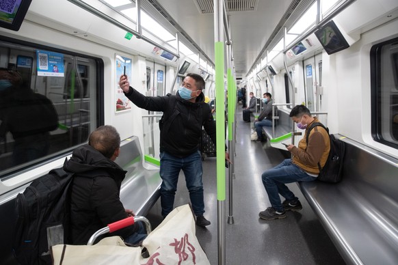 epa08327885 A passenger wearing a mask poses for a photo while riding the subway train in Wuhan, Hubei Province, China, 28 March 2020. The city of Wuhan, China&#039;s epicentre of the coronavirus outb ...