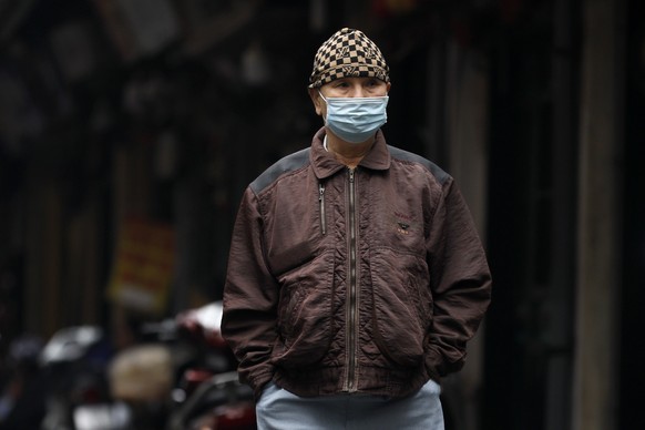 epa08924406 A man wearing a face mask walks at a street in Hanoi, Vietnam, 07 January 2021. Vietnam has agreed to buy some 30 million doses of the coronavirus disease (COVID-19) vaccine made by the Br ...