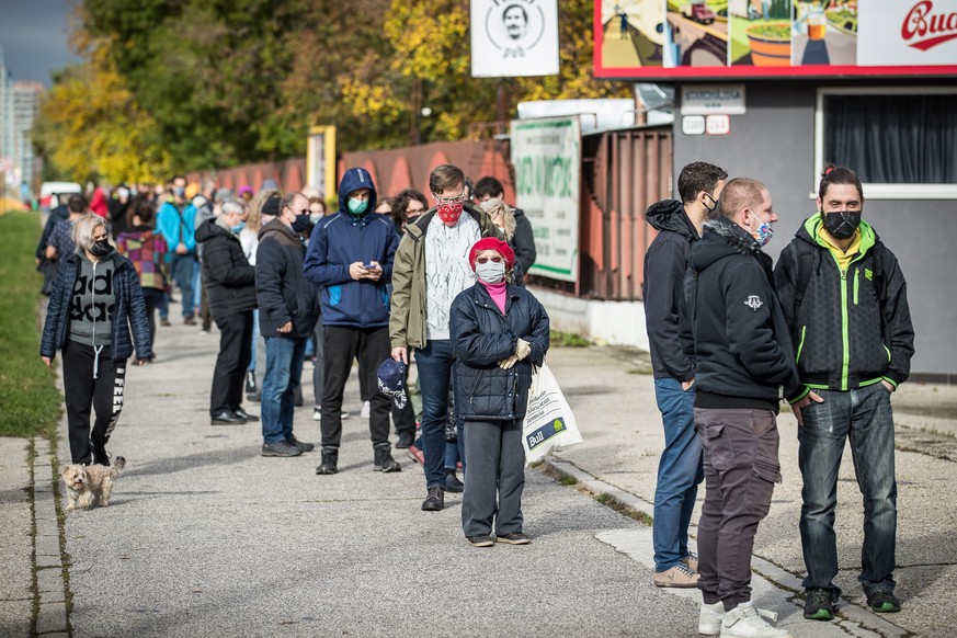 epa08788100 People wearing protective face masks wait in line at a coronavirus testing site during nationwide testing in Bratislava, Slovakia, 31 October 2020. EPA/JAKUB GAVLAK