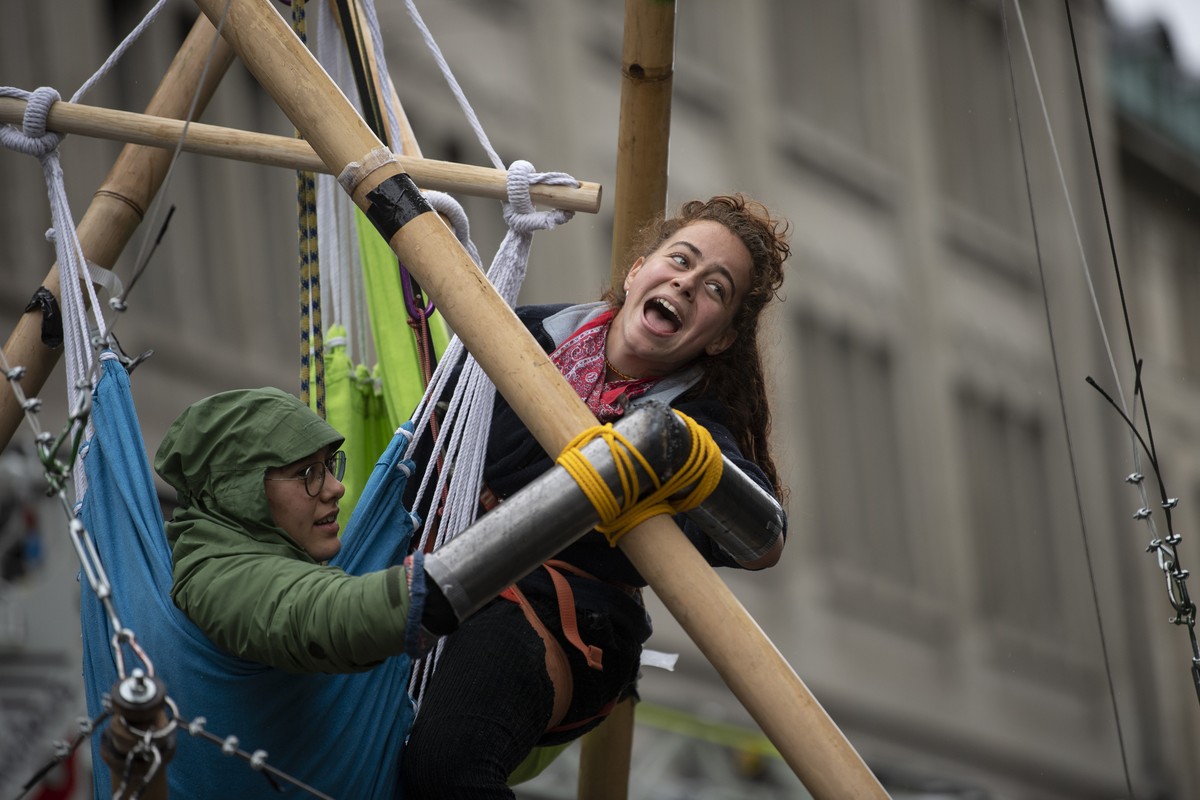 Menschen der Klimaorganisation "Extinction Rebellion" blockieren die Strasse in der Zuercher Innenstadt, aufgenommen am Dienstag, 5. Oktober 2021 in Zuerich. (KEYSTONE/Ennio Leanza)