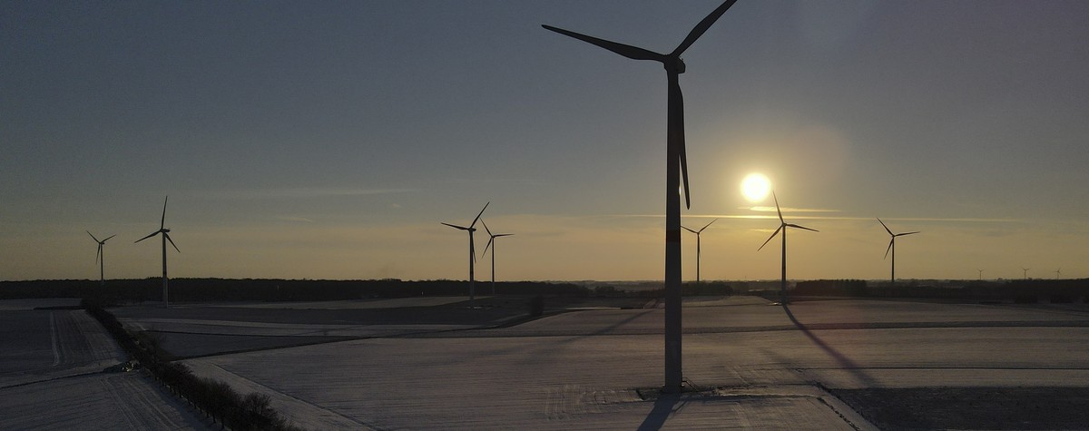 epa09004947 A picture taken with a drone shows a view over a windfarm at sunset in Grand Leez, Belgium, 11 February 2021. EPA/OLIVIER HOSLET