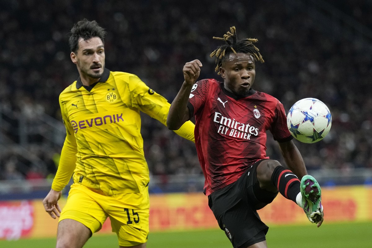 AC Milan's Samuel Chukwueze, right, challenges for the ball with Dortmund's Mats Hummels during the Champions League group F soccer match between AC Milan and Borussia Dortmund at the San Si ...