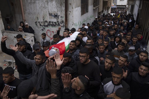 Mourners carry the body of Montaser Shawwa, 16, during his funeral in the West Bank refugee camp of Balata, Nablus, Tuesday, Feb. 21, 2023. Shawwa succumbed to his wounds that were sustained during an ...