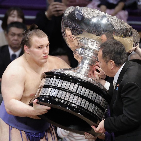 Ukrainian Aonishiki, left, receives a trophy after winning the Kyushu Grand Sumo Tournament in Fukuoka, western Japan, Sunday, Nov. 23, 2025. (Kyodo News via AP)
Japan Sumo