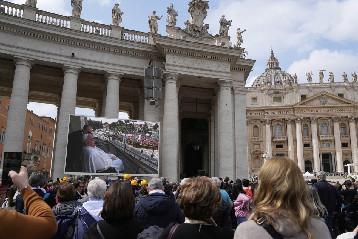 Faithful and pilgrims gather in St. Peter's Square at The Vatican to follow on giant screens a live broadcast from Rome's Agostino Gemelli Polyclinic, Sunday, March 23, 2025, where Pope Fran ...