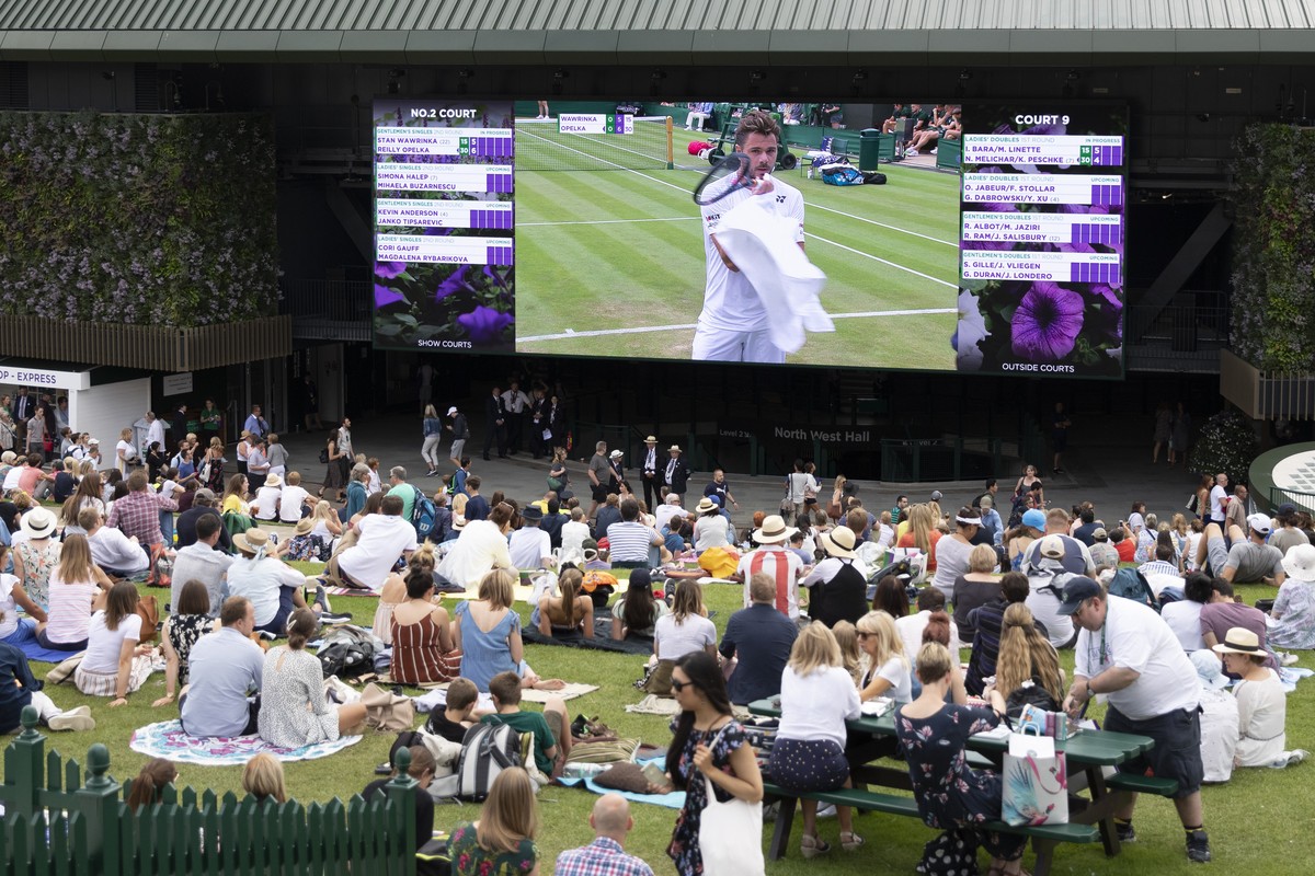 Spectators on Murray Mound (also known as "Henman Hill") watch Stan Wawrinka of Switzerland on a big screen during his second round match against Reilly Opelka of USA, at the All England Law ...