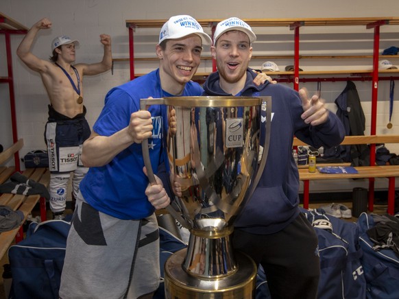 EV Zug Stuermer Reto Suri, Mitte, und Dominic Lammer, rechts, posieren mit dem Pokal in der Garderobe nach dem Sieg im Final des Swiss Ice Hockey Cups 2018/19 zwischen den SC Rapperswil-Jona Lakers un ...