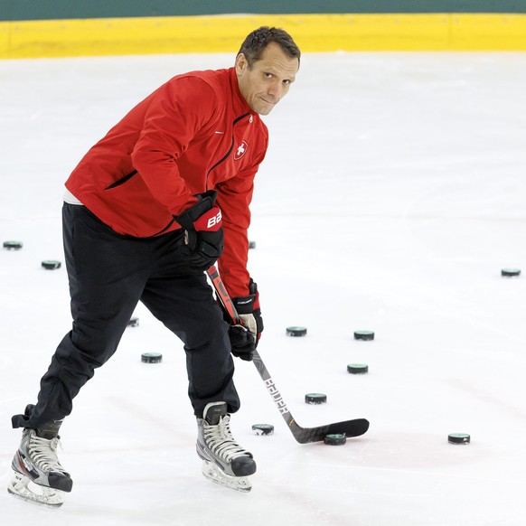 Marcel Jenni, assistant coach of Switzerland national ice hockey team, controls the puck, during an optional Switzerland team training session at the IIHF 2023 World Championship, at the Daugava Arena ...