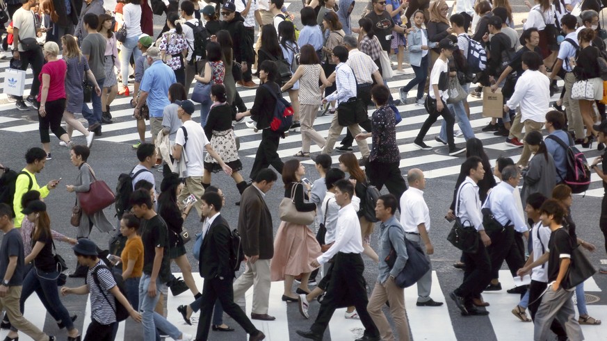 In this Sept. 29, 2017 photo, people cross streets at Tokyo&#039;s shopping and entertainment district of Shibuya in Tokyo. The Bank of Japan&#039;s quarterly survey shows an improved outlook for the  ...