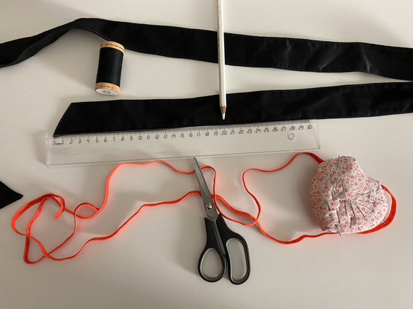 Du brauchst: Kleidergurt o. ä. (doppellagig), Gummitwist oder anderes elastisches Band, Nadel, Faden und Sicherheitsnadel.

