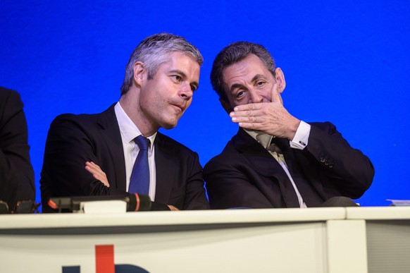 epa05015407 Former French president Nicolas Sarkozy (R) who is now the president of the &#039;Les Republicains&#039; (LR) party, talks with member of parliament Laurent Wauquiez (L) during the LR part ...