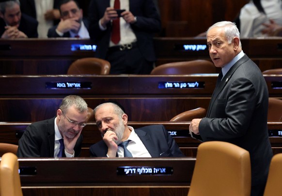 epa10545541 Israeli Prime Minister Benjamin Netanyahu (R), Israeli Justice Minister Yariv Levin (L) and Arie Deri (C) attend a voting session at the Knesset, Israel's parliament, in Jerusalem, Israel...