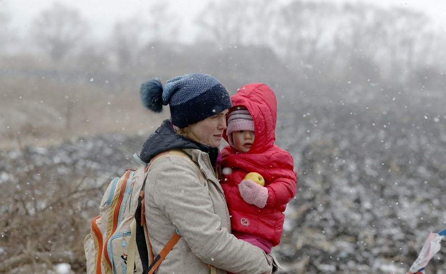 epa09807501 A Ukrainian mother holds her baby as she passes through the border crossing of Siret, northern Romania, 07 March 2022. Since Russia began its military operation in Ukraine on 24 February,  ...