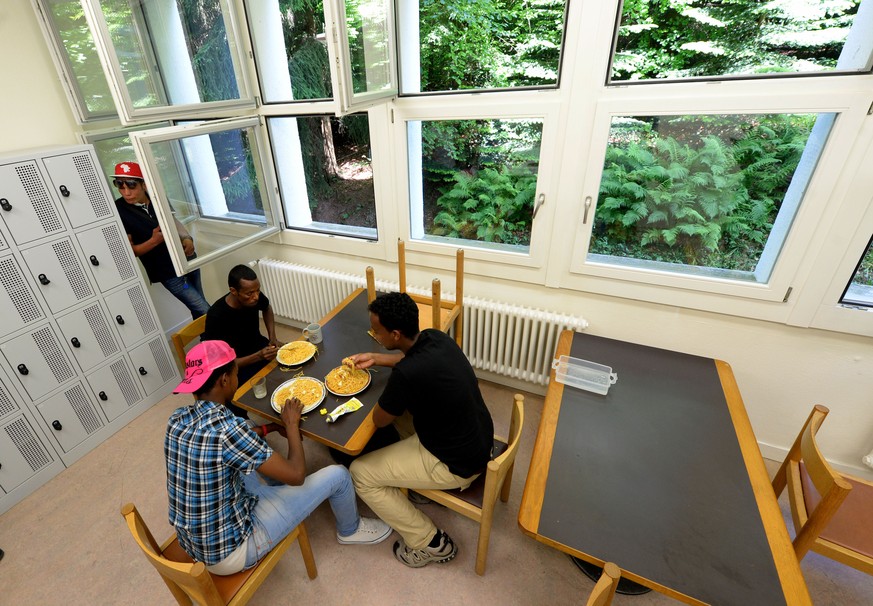 Asylbewerber verpflegen sich in einem Aufenthaltsraum im Asylzentrum Hirschplatz in Luzern.