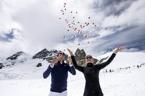 IMAGE DISTRIBUTED FOR LINDT – Switzerland’s champion tennis player Roger Federer and US champion ski racer Lindsey Vonn throw chocolates into the air after an exhibition tennis match between them on t ...