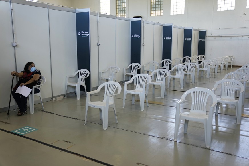 A woman sits in the nearly empty waiting room of a vaccination center in Lisbon, Tuesday, Sept. 21, 2021. As Portugal nears its goal of fully vaccinating 85% of the population against COVID-19 in nine ...