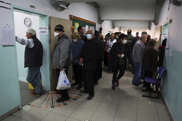 People stand in a queue as they wait to vote at a polling station in Ankara, Turkey, Sunday, May 14, 2023. Voters in Turkey go to the polls on Sunday for pivotal parliamentary and presidential electio ...