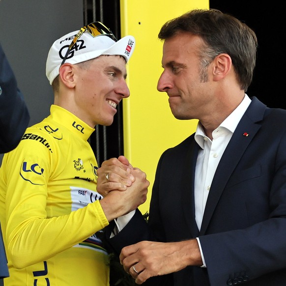 epa12243410 Slovenian rider Tadej Pogacar (L) of UAE Team Emirates XRG shakes hands with France&#039;s President Emmanuel Macron in his leader yellow jersey after after winning the 12th stage of the T ...