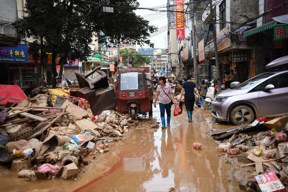KEYPIX - epa12186560 Residents walk on a flood-hit road in Huaiji County, Guangdong Province, China, 19 June 2025 (issued 20 June 2025). The National Development and Reform Commission said on 18 June  ...