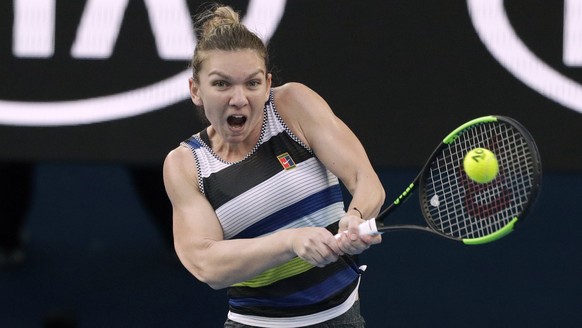 Romania's Simona Halep makes a backhand return to United States' Serena Williams during their fourth round match at the Australian Open tennis championships in Melbourne, Australia, Monday, Jan. 21, 2019. (AP Photo/Kin Cheung)