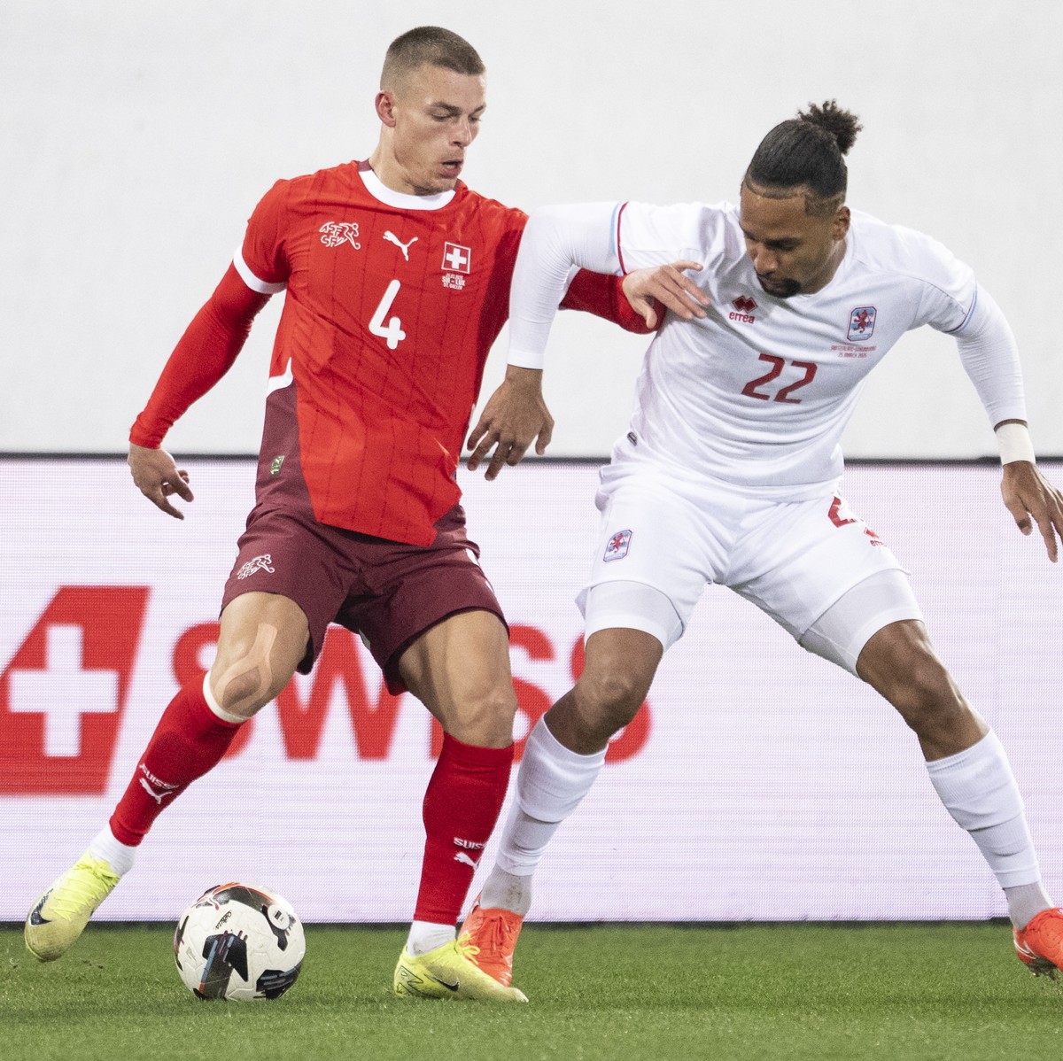epa11988242 Switzerland's Miro Muheim (left) fights for the ball against Luxembourg's Marvin Martins (right) during a friendly soccer match between Switzerland and Luxembourg at the Kybunpar ...