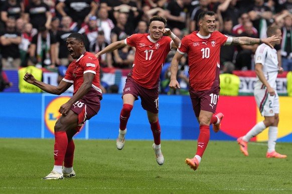 Switzerland&#039;s Kwadwo Duah, left, celebrates after scoring his side&#039;s opening goal besides team mates Ruben Vargas, center, and Granit Xhaka during a Group A match between Hungary and Switzer ...
