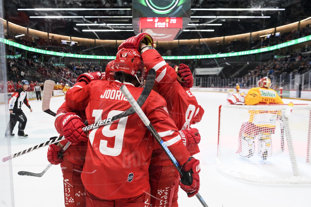 Les joueurs lausannois avec l'attaquant lausannois Josh Jooris, de dos, celebrent le 3eme goals devant le gardien de Langnau Gianluca Zaetta, droite, lors du match du championnat suisse de hockey ...