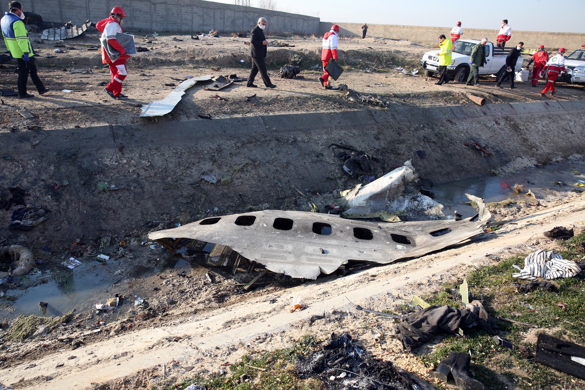 epa08118592 (FILE) - Officials stand near the wreckage after an Ukraine International Airlines Boeing 737-800 carrying 176 people crashed near Imam Khomeini Airport in Tehran, killing everyone on boar ...