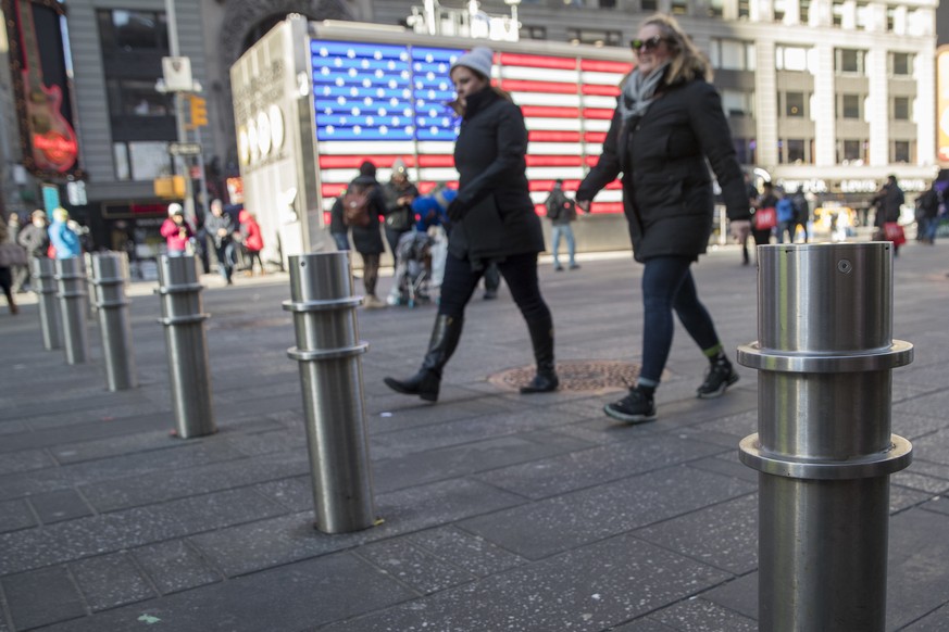 Pedestrians walk past protective barriers installed in New York&#039;s Times Square, Tuesday, Jan. 2, 2018. Hundreds of new protective barriers will be permanently installed in Times Square and other  ...