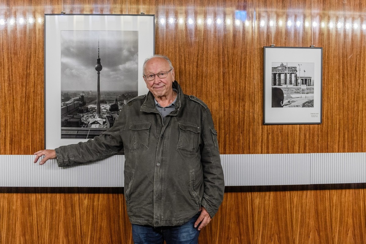 epa07882051 German photographer Thomas Billhardt poses in front of his pictures in the Berlin TV tower during a press conference on the occasion of the 50th anniversary of the landmark building in Ber ...