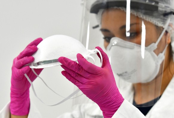 epa08436522 An employee checks a face mask during the manufacturing process in Mexico City, Mexico, 21 May 2020. The Government of Mexico City supports a project with the National Autonomous Universit ...