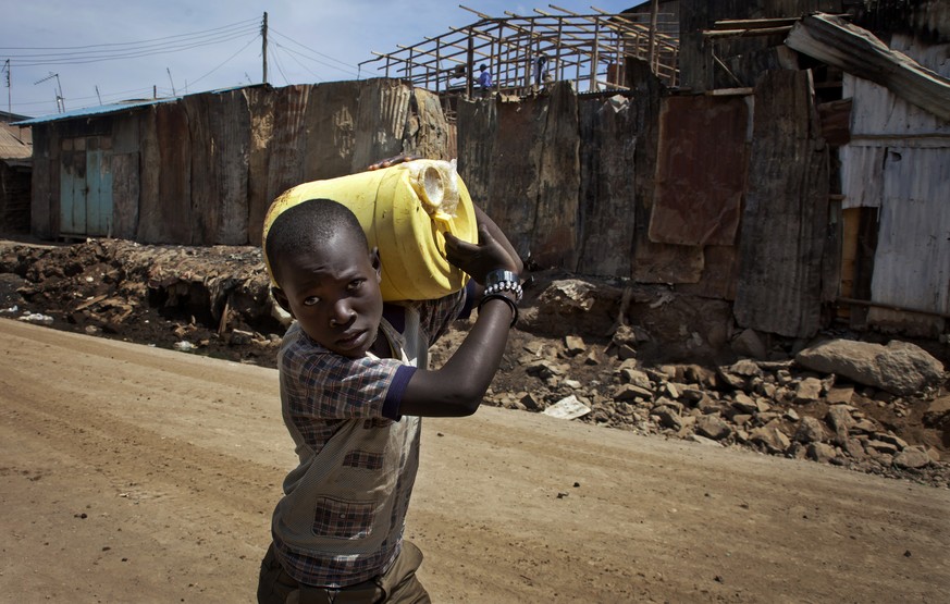 Ein Junge schleppt Trinkwasser in Kenia.