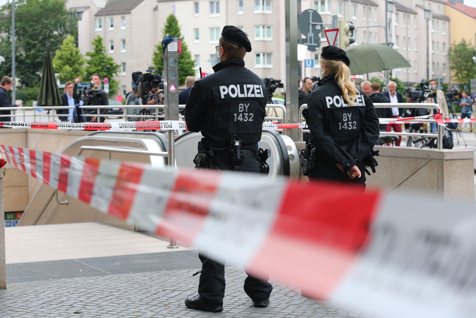 epa05437447 Police officers are seen behind a cordoned off area blocking the access to the underground station Olympia shopping center in Munich, Germany, 23 July 2016, after a shootout on the previou ...
