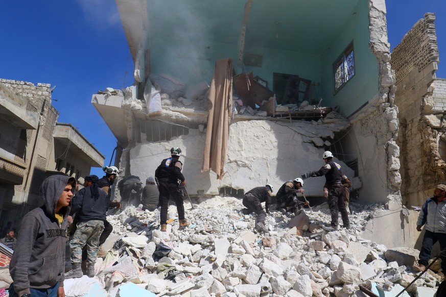 People and civil defence personnel remove rubble as they look for survivors at a damaged site after an air strike on rebel-held Idlib city, Syria March 19, 2017. REUTERS/Ammar Abdullah