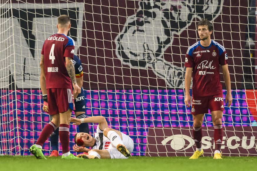 L&#039;attaquant luganais Zan Celar, centre, reagit apres un choc avec le defenseur genevois Steve Rouiller, gauche, lors de la rencontre de football de Super League entre Geneve Servette FC et FC Lug ...