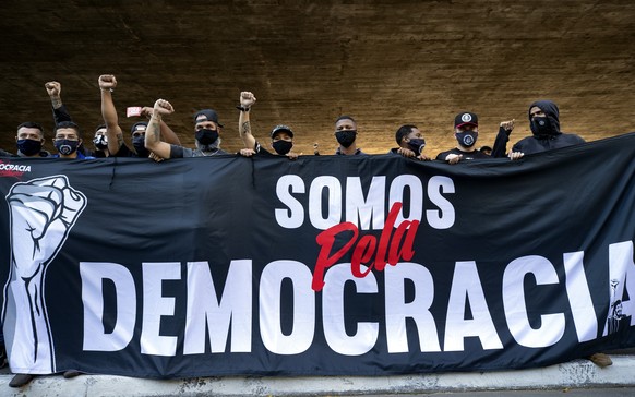 Fans of two distinct soccer clubs hold a banner that reads in Portuguese &quot;We are for Democracy,&quot; as they joined forces for an anti-government protest in Sao Paulo, Brazil, Sunday, May 31, 20 ...