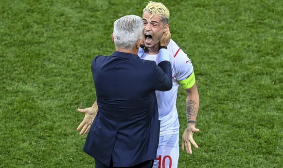 Switzerland's Granit Xhaka celebrates with manager Vladimir Petkovic after defeating France in a penalty shoot out during the Euro 2020 soccer championship round of 16 match between France and Switzer ...