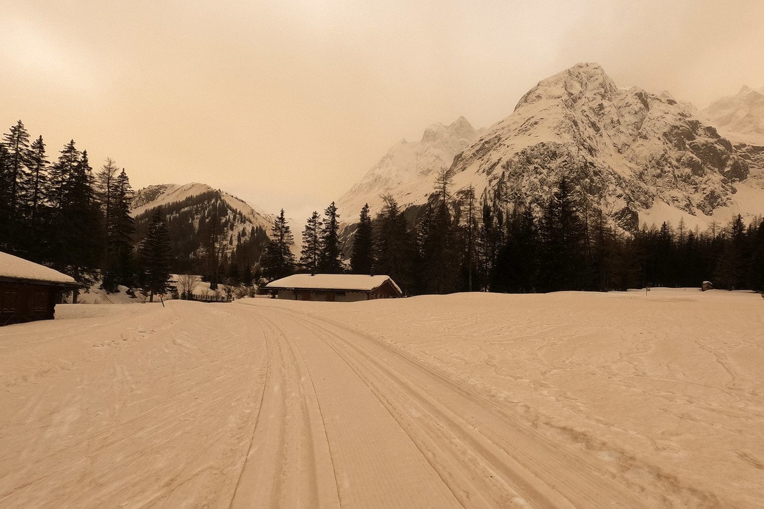 Vue de la piste de ski de fond recouverte de sable, ce samedi 6 fevrier 2021 a La Fouly dans le Val Ferret. Le sable du Sahara a visiblement obscurci le ciel a certains endroits en Suisse samedi. Ce p ...